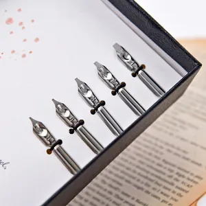Gros plan de cinq plumes de rechange pour calligraphie vintage dans un coffret cadeau noir.