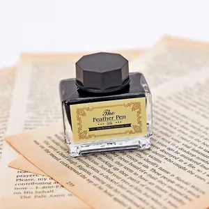 Détail d'un flacon d'encre noire vintage pour plumes sur des pages de vieux livres