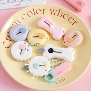 Mini couteaux utilitaires mignons en forme d'os et de biscuit sur une assiette