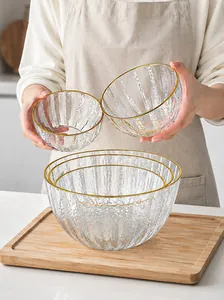 Détail des bols à salade en verre texturé avec une élégante finition à bord doré.