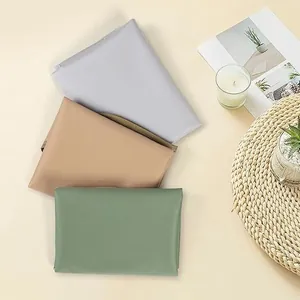High-quality detailed view of folded waterproof adult bibs in grey, tan, and green colors.