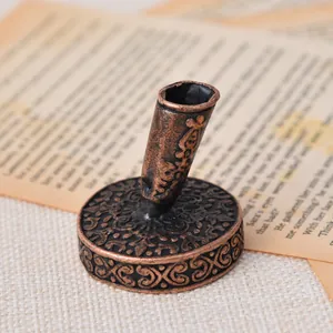 Close-up of vintage bronze carved metal pen base on retro paper background