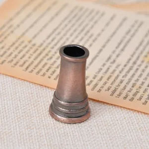Primer plano de un portabolígrafos vintage de bronce con textura antigua y detalles