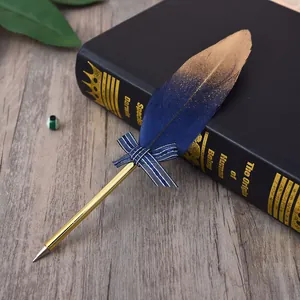 Close-up of elegant blue and gold feather ballpoint pen with decorative bow