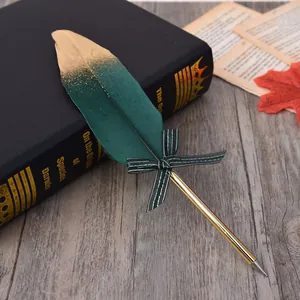 Close-up of elegant gold-sprayed green feather quill pen with a striped bow detail