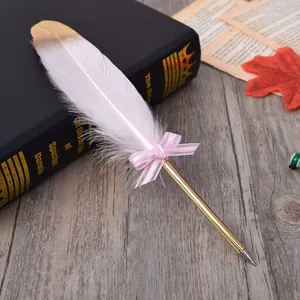 A detail view of elegant white feather ballpoint pen decorated with a pink bow ribbon