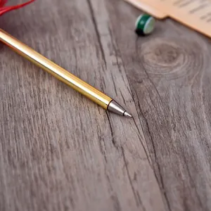 Close-up of elegant gold ballpoint pen on wooden background