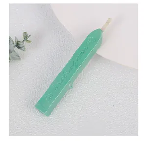 Macro detail of a mint green pearlescent sealing wax stick with a wick for envelope stamps