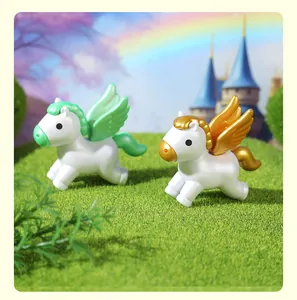 Macro view of mini Pegasus figurines with green and gold wings on a lush grass field