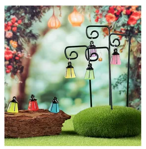 Mini linternas luminosas colgadas en soportes para decoración de micropaisajes.