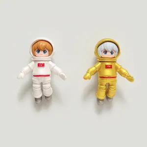 Close-up of mini white and gold resin astronaut figurines for micro-landscapes