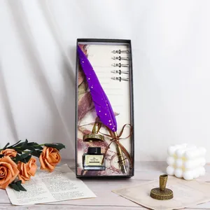 Vintage purple quill pen set with gold leaf detail in an elegant gift box arrangement.