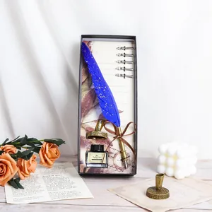 Detailed macro view of vintage blue feather quill pen gift set with ink bottle and nibs