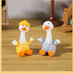 Close-up of two cute resin goose figurines in colorful polka dot pajamas for desktop decor