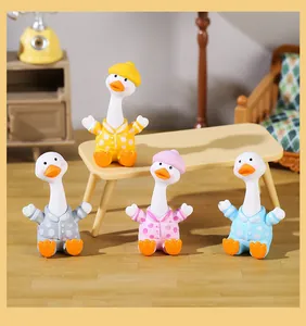 Close-up of four cute resin white goose figurines in colorful polka-dot pajamas