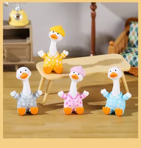 Four cute resin goose figurines in colorful polka-dot pajamas in miniature room