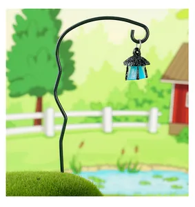 Vista detallada de un gancho de jardín de hierro negro con un pequeño farol azul