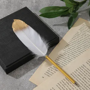 Nahaufnahme eines weißen Federkugelschreibers mit Goldspitze auf alten Buchseiten.