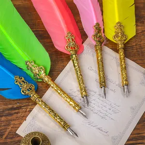 Vintage veren dompelpenset met sierlijke goudkleurige houders en gekleurde veren