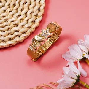 Detailed view of a gold mesh bracelet decorated with rhinestone star and heart charms