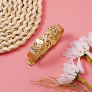 Detail of gold mesh bracelet with rhinestone star and Best Friend heart charms.
