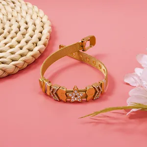 Detailed macro view of gold mesh bracelet with sparkling rhinestone heart and star charms