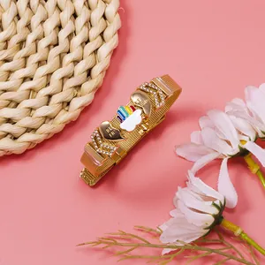 Detailed macro view of gold mesh bracelet with rainbow cloud and best friend heart charms