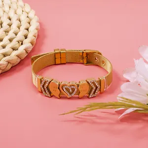 Detail shot of a gold mesh bracelet with sparkling rhinestone heart and BFF charms