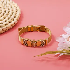 Detail view of a Maillard-style gold mesh bracelet with heart and cross rhinestone charms.
