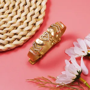 Detail shot of a gold mesh bracelet featuring "Best Friend" engraved heart charms.