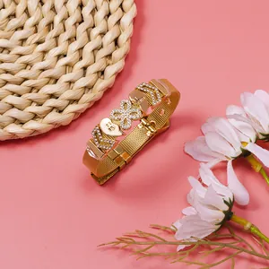 Detailed view of a gold mesh bracelet featuring 'Best Friend' hearts and crystal clover charms.