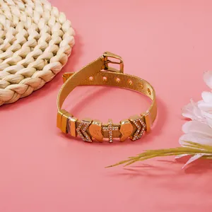 Detailed view of a gold mesh bracelet with rhinestone heart and cross charms.