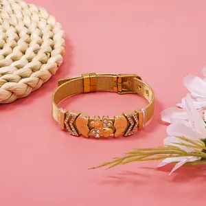 Detailed macro view of gold mesh bracelet with heart and clover rhinestone charms