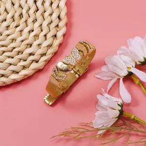 Detailed macro shot of a golden mesh bracelet with sparkling rhinestone butterfly charms