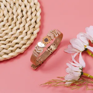 Rose gold mesh bracelet featuring sunflower and heart charms on a textured pink backdrop.