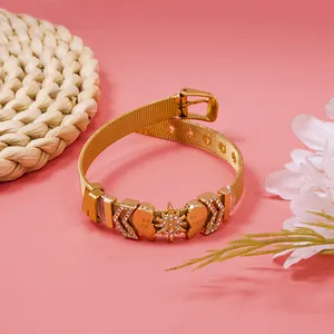 Close-up detail of golden mesh friendship bracelet with sparkling crystal heart and star