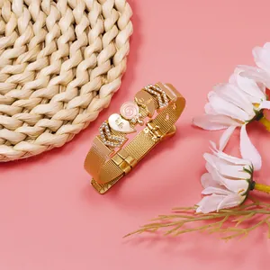 Detailed macro shot of a gold mesh bracelet featuring rhinestone heart charms