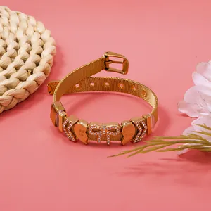 Close-up of gold mesh belt bracelet featuring sparkling rhinestone heart and bow charms