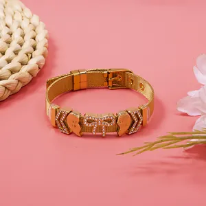 Close-up of gold mesh bracelet with rhinestone heart and bow "Best Friend" charms.