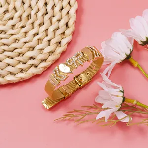 Close-up of gold mesh bracelet with rhinestone KIRA letters and Best Friend heart charm.