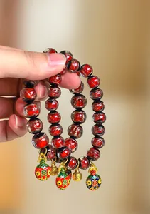 Gros plan sur des perles en verre de cendres d'encens rouges avec breloques porte-bonheur