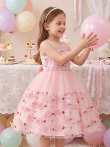 Young girl in a pink lace embroidered dress holding a balloon in a party setting