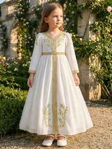 Full view of girl's white long ethnic dress with elegant golden embroidery in a garden