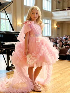 Detail view of pink ruffled high-low princess dress for girls on a performance stage