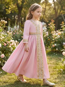 Full view of a girl's elegant pink ethnic dress featuring gold lace embroidery in a garden
