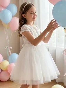 Detailansicht eines eleganten weißen Spitzen- und Tüllkleids für festliche Anlässe