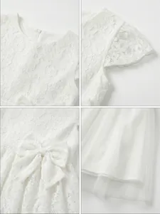 Close-up of white floral lace fabric and mesh hem of a girl's princess dress.