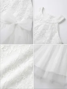 Detailed view of elegant white floral lace embroidery and soft tulle mesh dress.