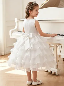 Detailed back view of white ruffled flower girl dress with large bow accent