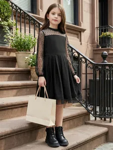 Elegante abito nero in tulle a pois da bambina su scale classiche esterne.